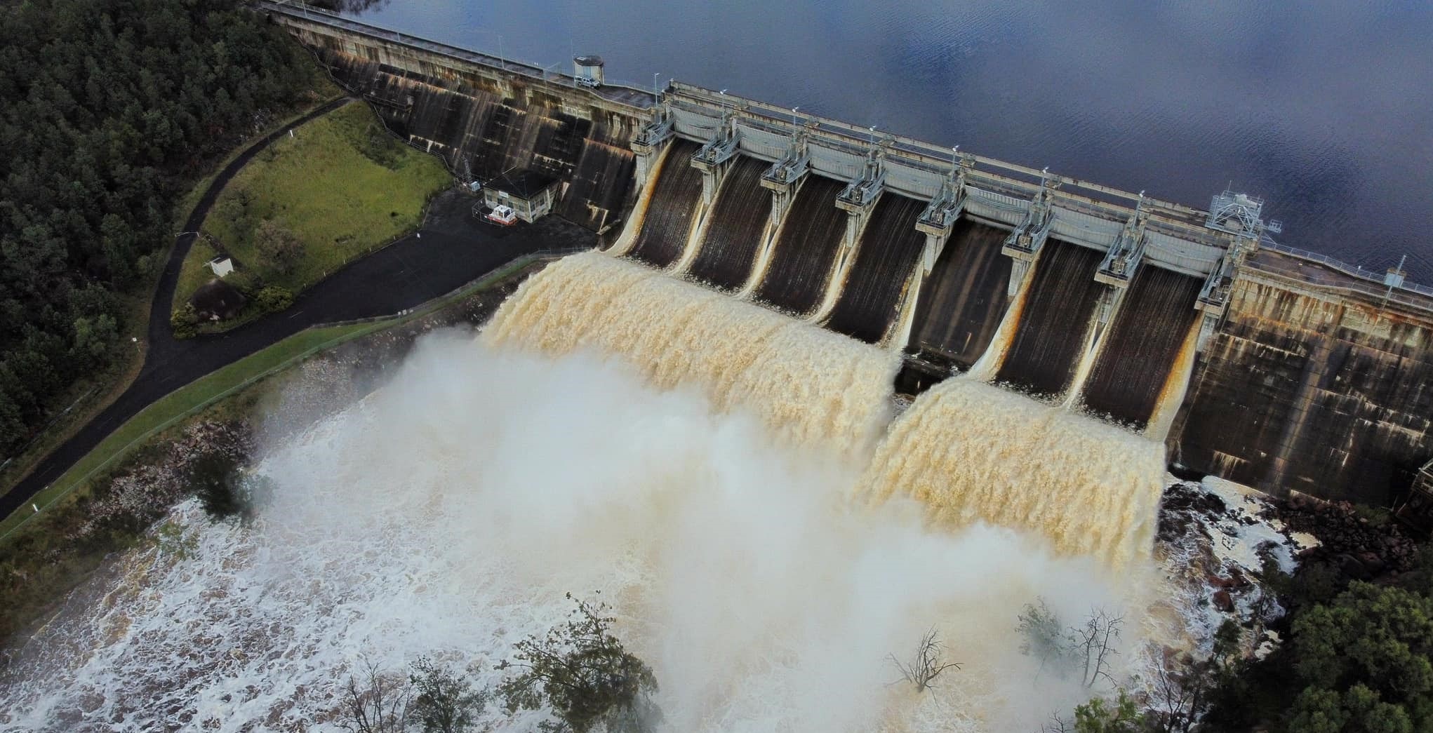 A lot of water rushes over a dam spillway