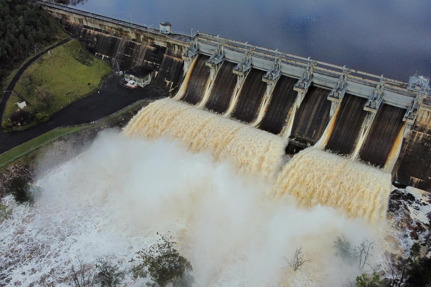 A lot of water rushes over a dam spillway
