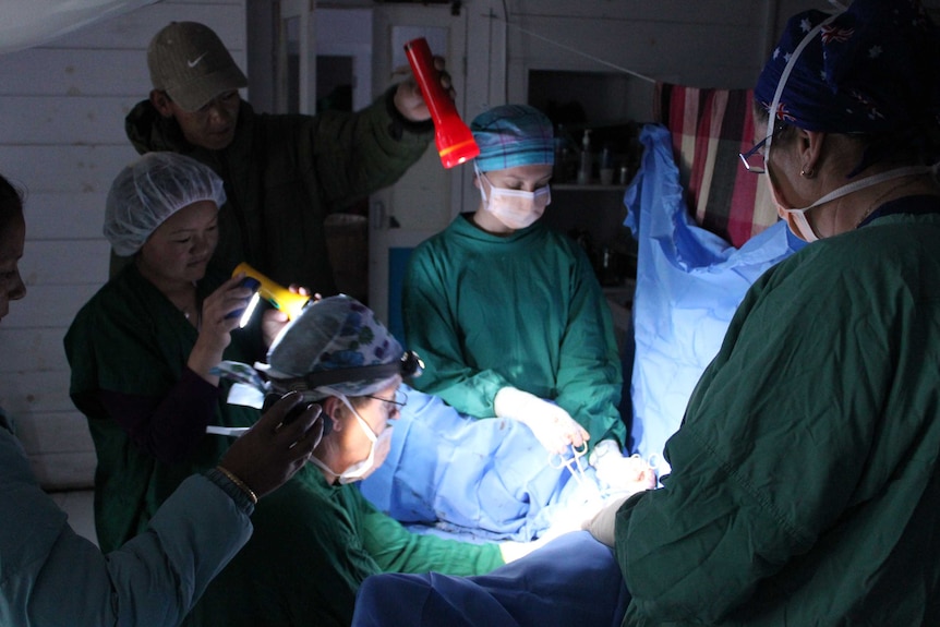 An Australians for Women's Health team conducts an operation in Nepal by torchlight.
