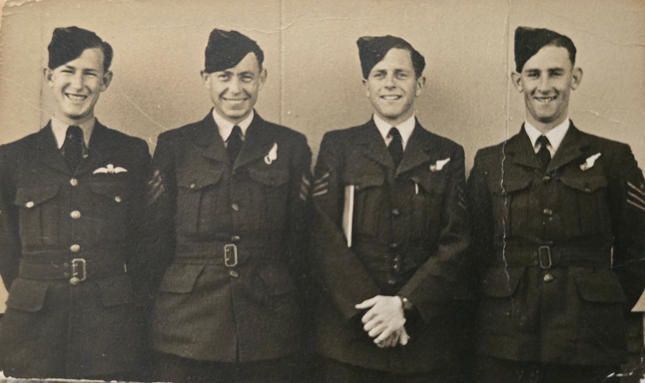 A sepia photograph of four smiling young men in RAAF uniforms, circa World War II.