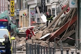 Rescue workers searching in debris of collapsed buildings.