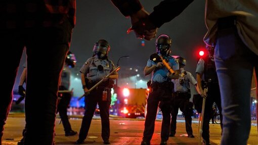 Minneapolis police seen past protestors holding hands