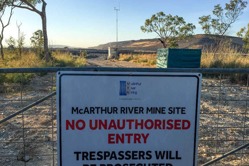 A sign warning 'no unauthorised entry' on a gate leading into the McArthur River mine.