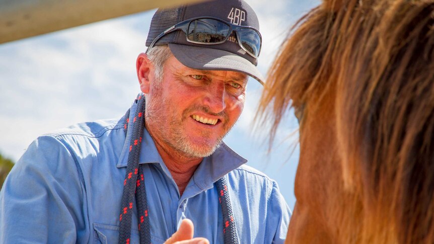 Joe Hughes looks into the face of a horse