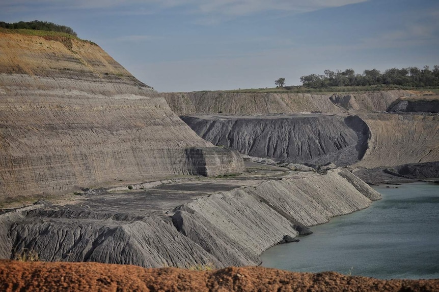 A large open-cut coal mine on a sunny day.