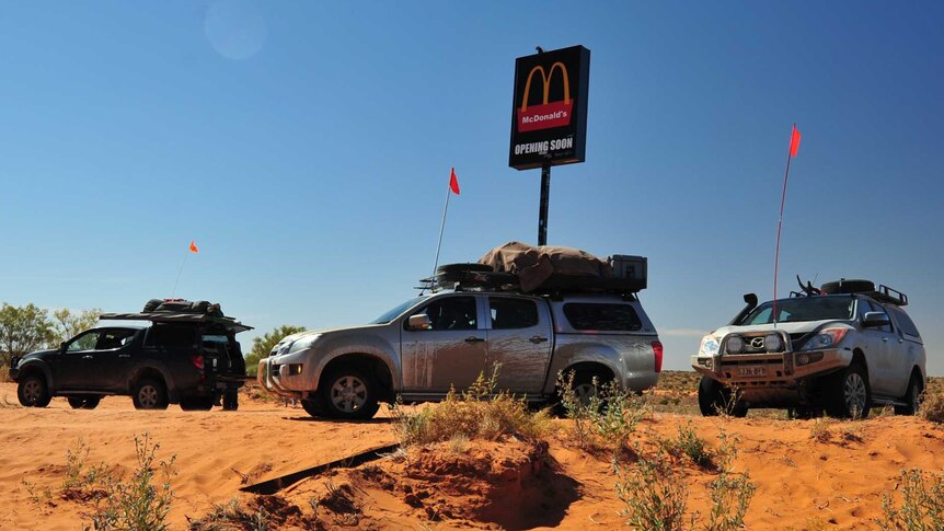 Cars around Simpson Desert McDonald's sign