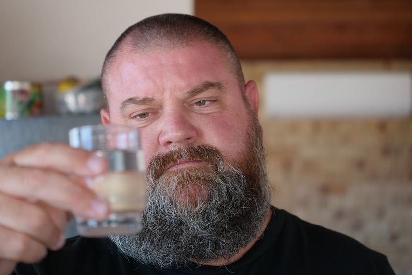 A man holds up a glass 