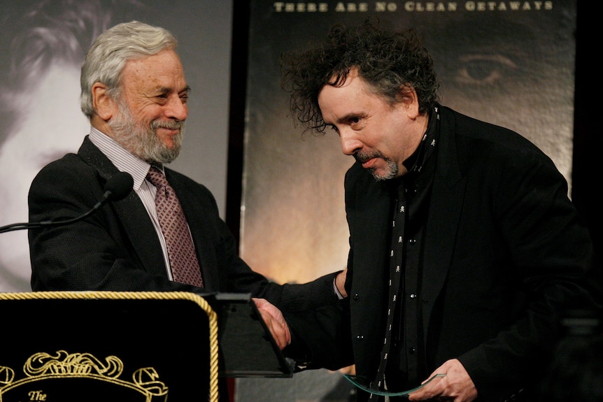 Stephen Sondheim shakes the hand of Tim Burton