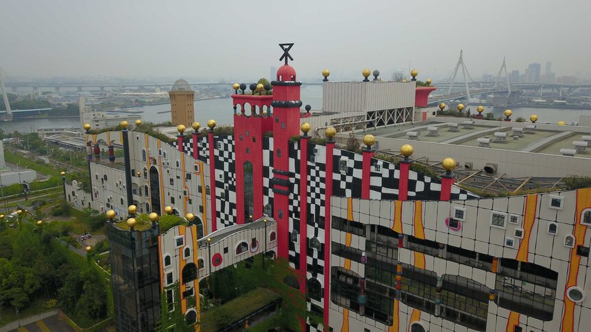 An aerial shot of the Maishima Incineration Plant in Osaka, with the city and the river in the background.