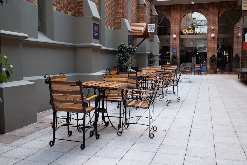 A picture of empty cafe tables and chairs in a Perth CBD laneway.