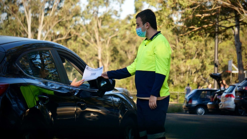 A man presents paperwork at a COVID-19 testing site in Sydney.