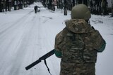 A soldier patrols a snow-covered street