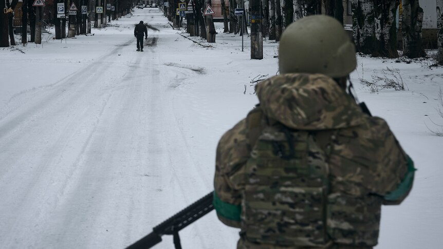 A soldier patrols a snow-covered street