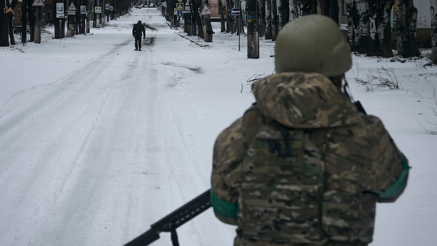 一名士兵在白雪覆盖的街道上巡逻