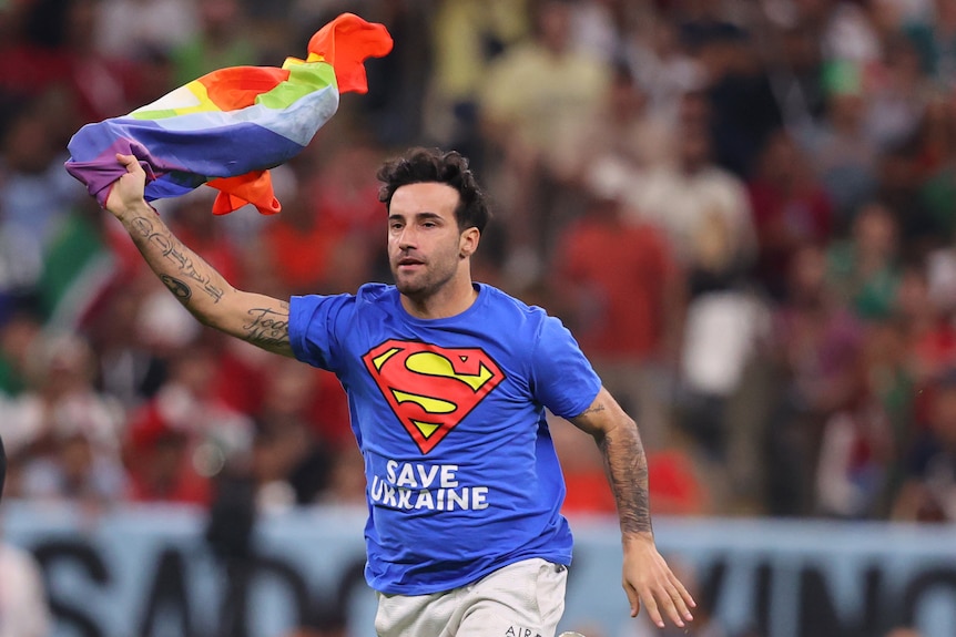 Протестиращ, носещ знаме с дъга, тича на терена на Световното първенство в Катар
