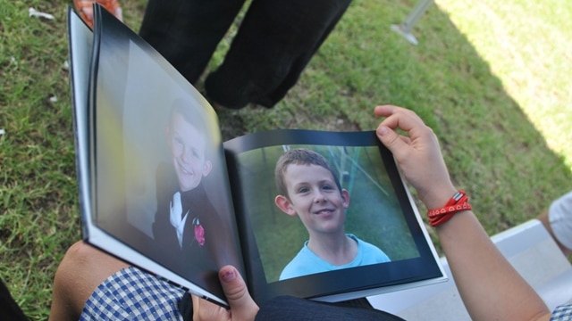 A student looks at a photo of nine-year-old Harry Dunn.