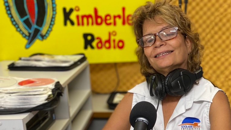 Sandy Dann sitting behind a radio panel producing her show