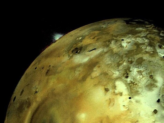 A close-up view of the surface of Jupiter's moon, Io, which is an odd brown-green in colour