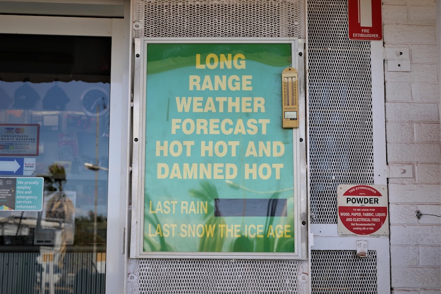 A sign in a shop window what says 'long range weather forecast hot hot and damned hot'