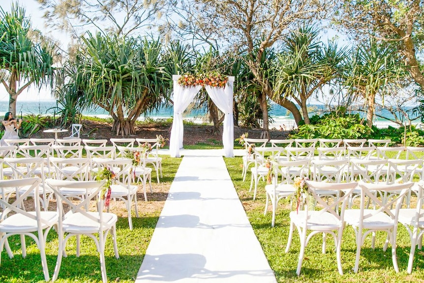 Seats and arch set up by the beach for a wedding.