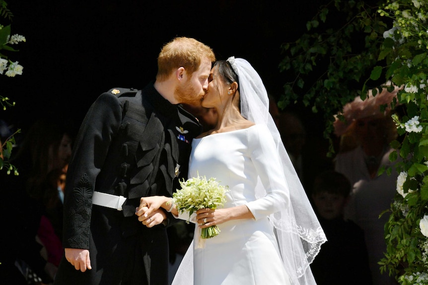 Prince Harry and Meghan Markle kiss outside the chapel.