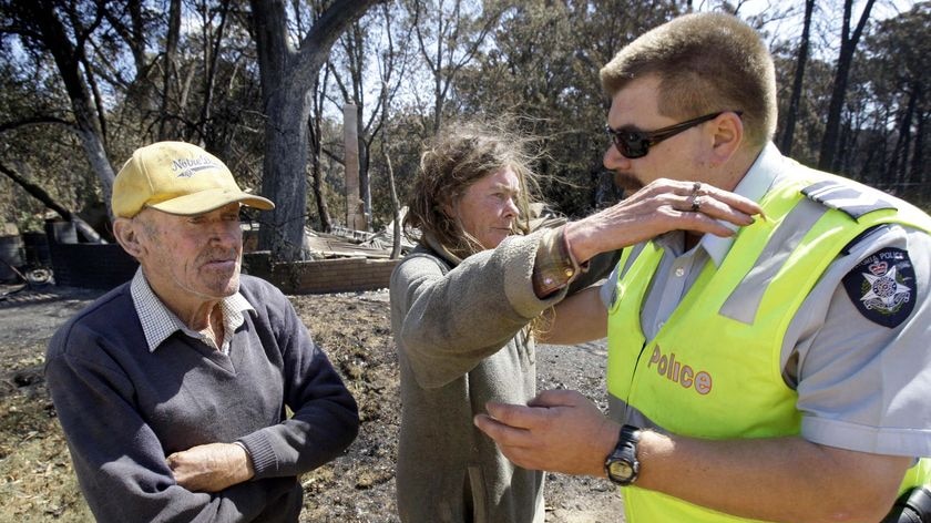 Jane Cameron hugs local police officer Andrew Lodi as Greg Annand stands by