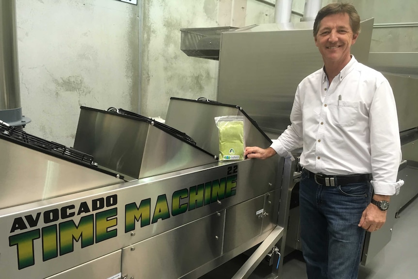 Jeff Hastings poses next to the steel avocado time machine, holding a packet of avocado pulp.