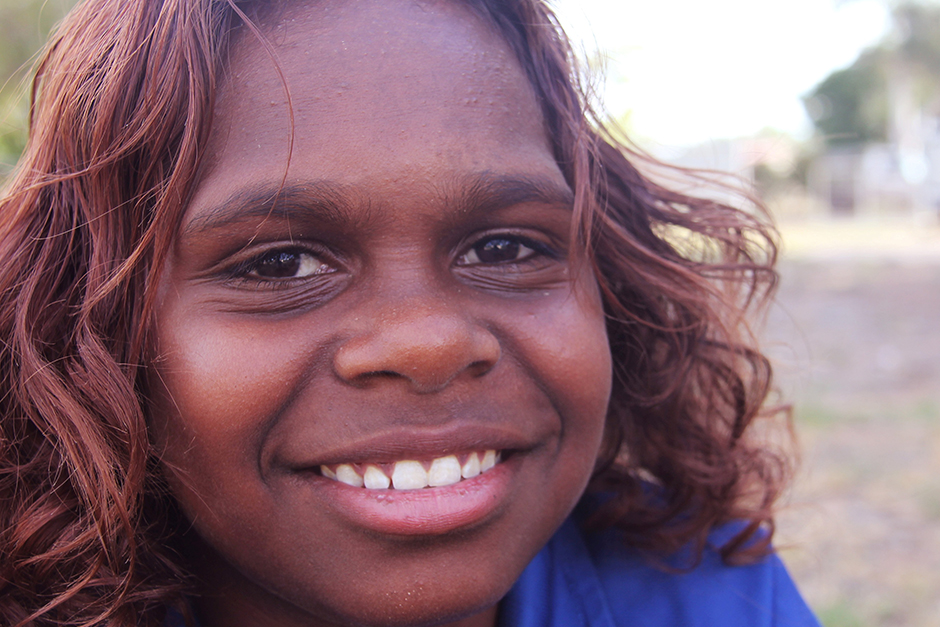 A young Aboriginal woman looks directly at the camera