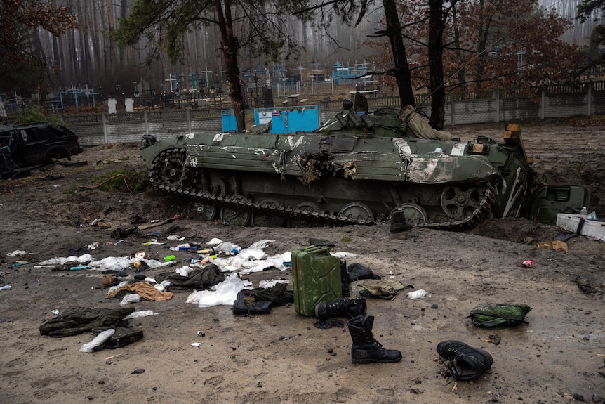 Military gear left behind by Russian soldiers lay scattered near a tank.