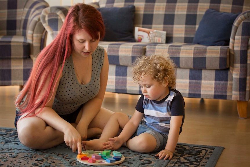 Jo Wright plays with her 2-year-old son Philip on the carpet in the home in Western Sydney.