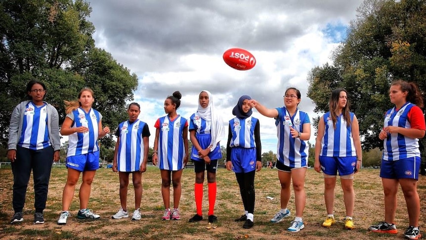 Members of North Melbourne's Huddle community harmony group test their AFL skills