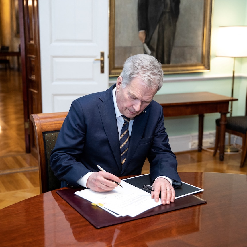 Finnish President Sauli Niinisto signs Finland's national NATO legislation.