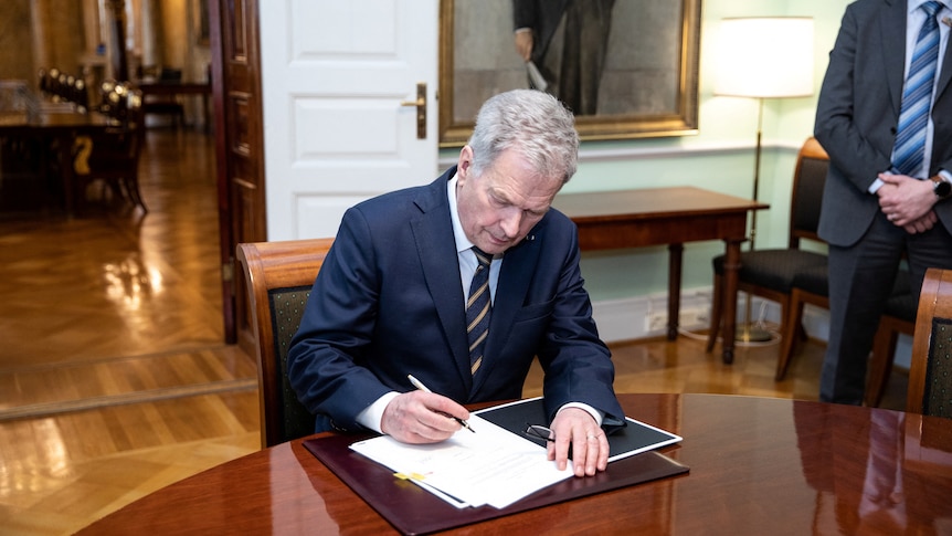 Finnish President Sauli Niinisto signs Finland's national NATO legislation.