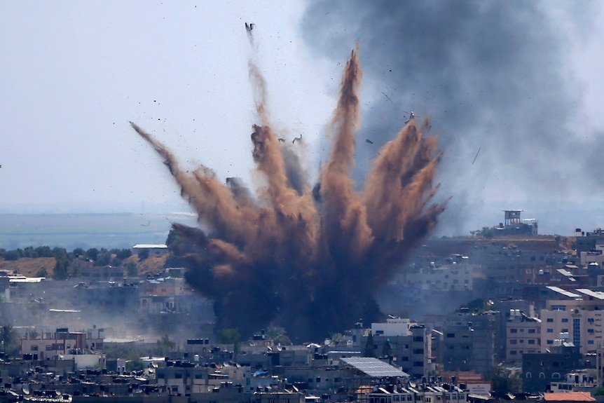 A large cloud of smoke rises following an airstrikes on a building in Gaza City 
