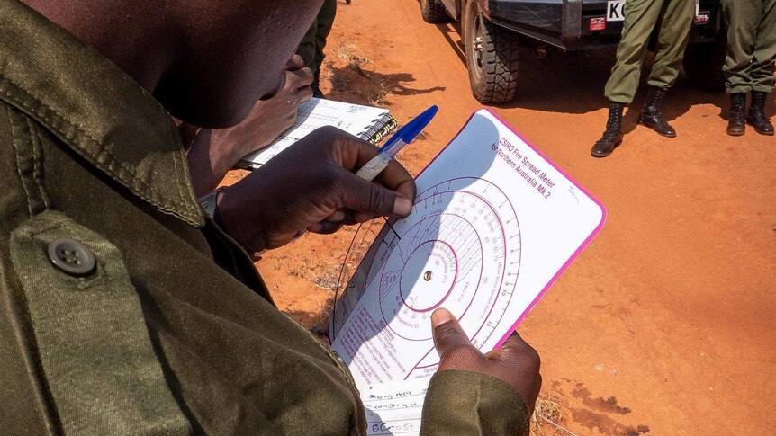 A ranger holds in his hand a diagram with a number of concentric circles.