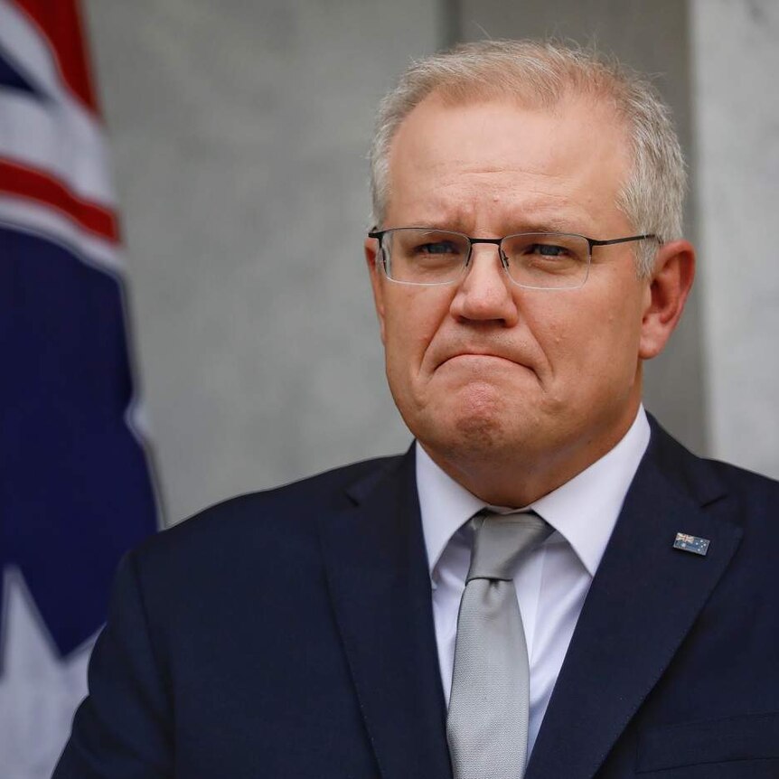 Scott Morrison frowns while listening to a question.