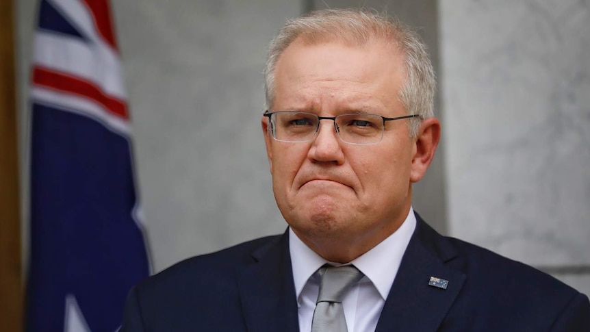 Scott Morrison frowns while listening to a question.