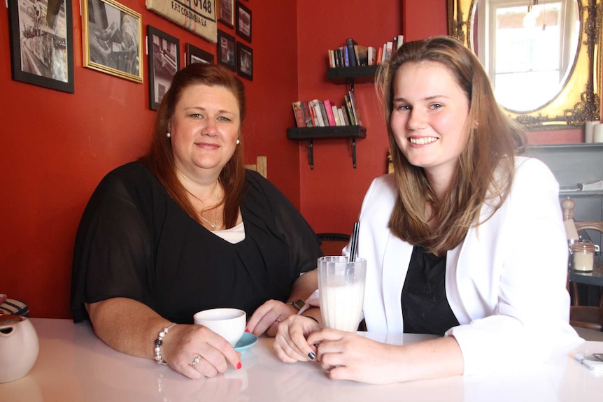 Marijke Phillips (left) has sits with Leatisha Phillips (right) at a table.