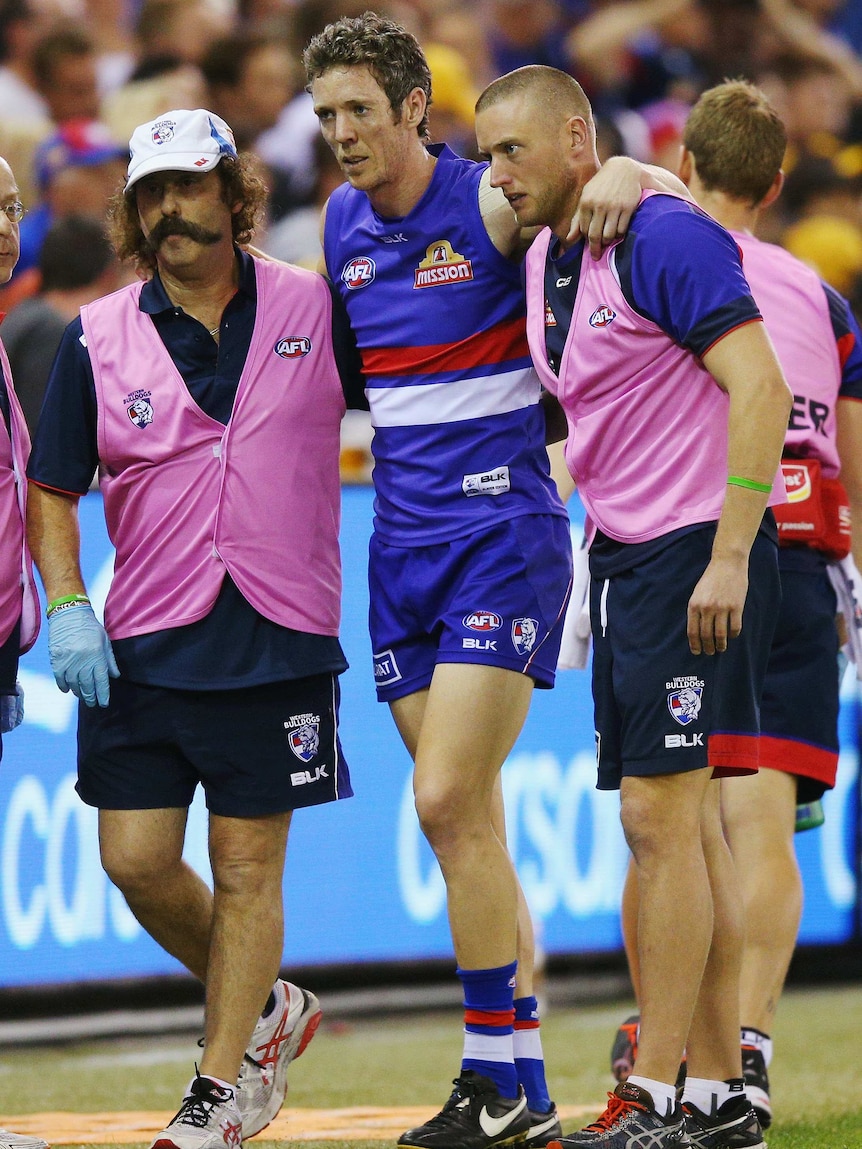 Western Bulldogs' Robert Murphy is helped off after sustaining a knee injury against Hawthorn.