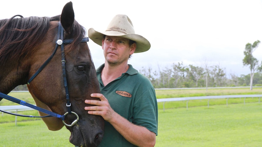 Brown horse with man in battered hat