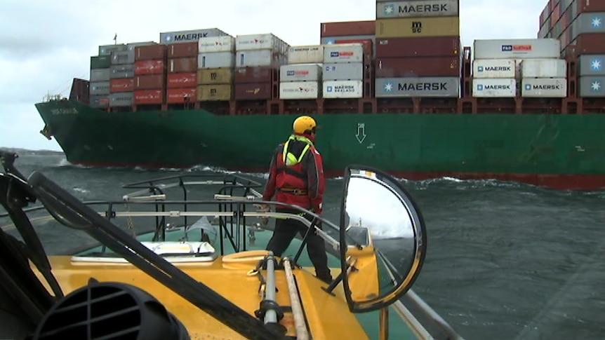 A marine pilot boat heads out to meet a cargo ship.