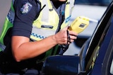 A Victoria Police officer stops a driver to conduct a breath test.