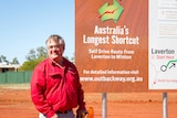 Shire President, Patrick Hill standing in front of the brand new Outback Way sign in Laverton.