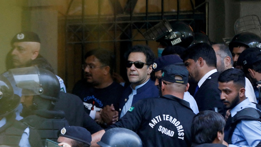 Security officers escort Pakistan's former Prime Minister Imran Khan.