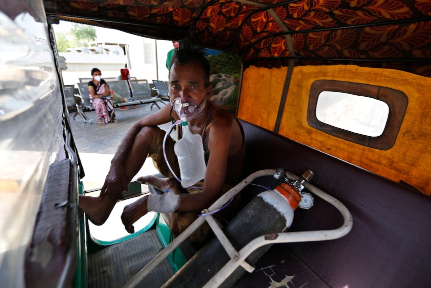 A COVID-19 patient breathes with the help of an oxygen mask.