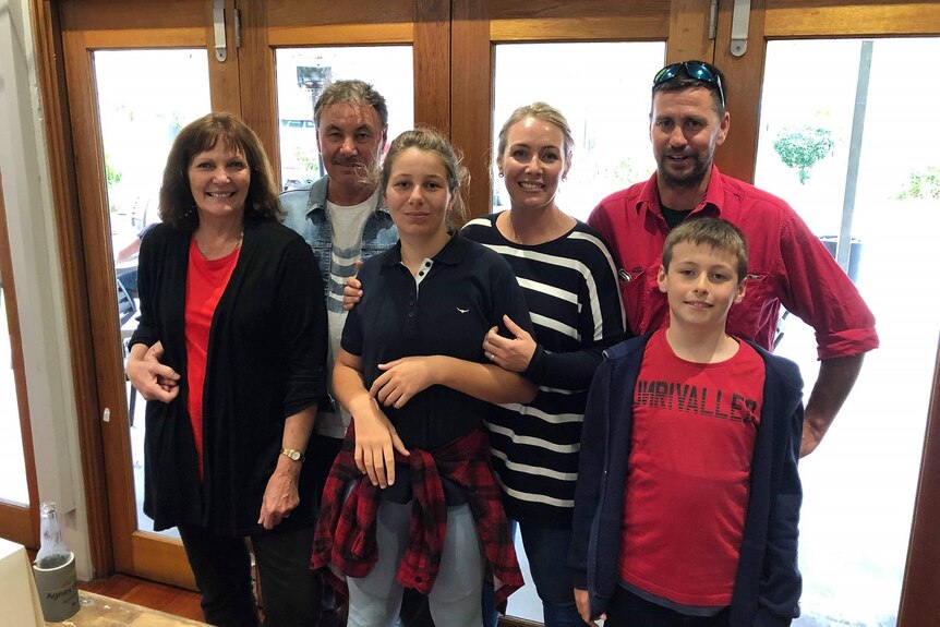 Narelle and five family members standing together smiling.