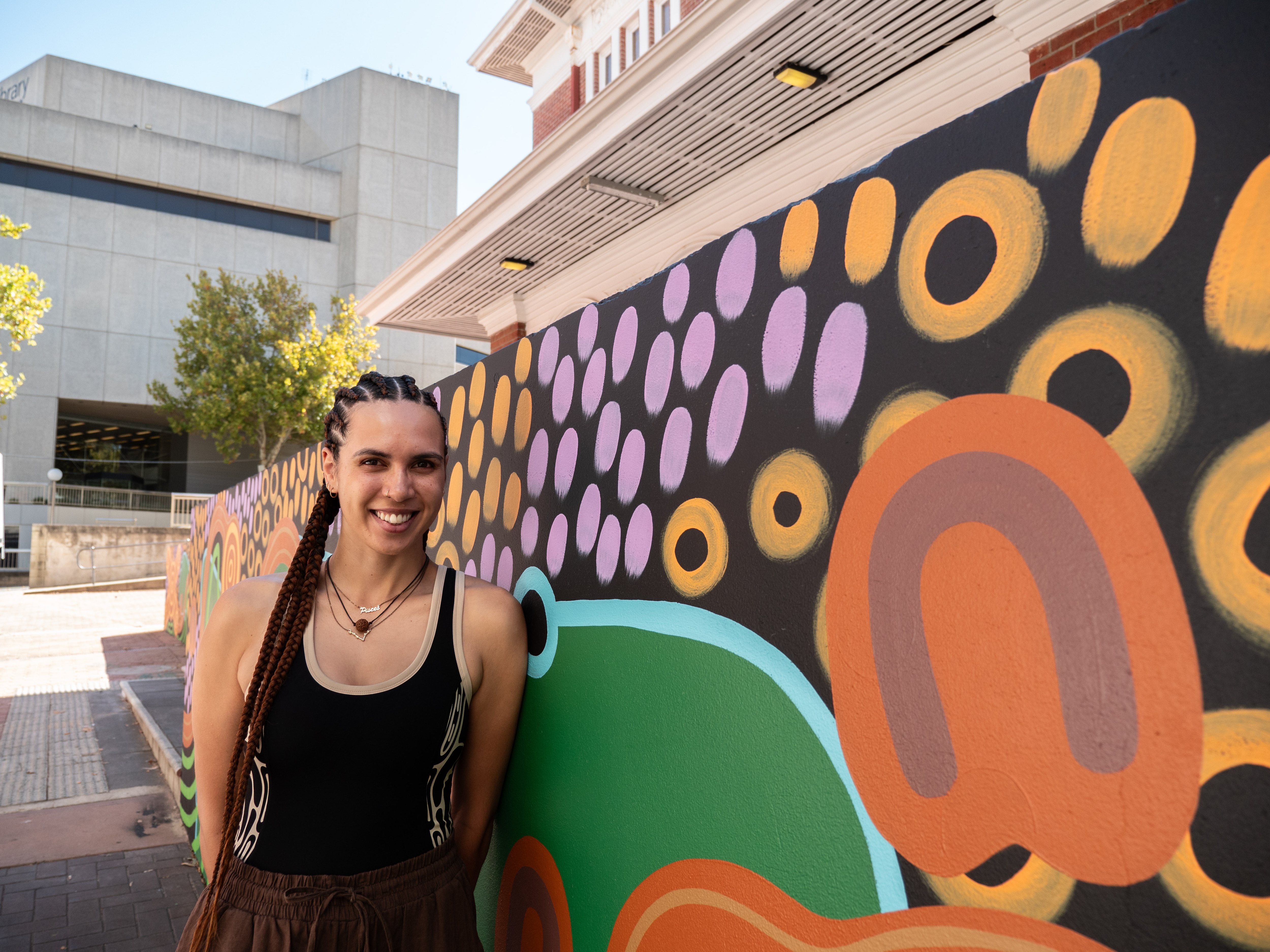 Artist J.D. Penangke  with the mural she designed for PICA's new entrance and foyer