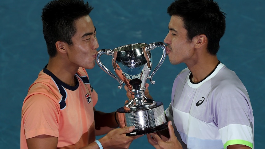 Rinky Hijikata and Jason Kubler kiss a silver trophy