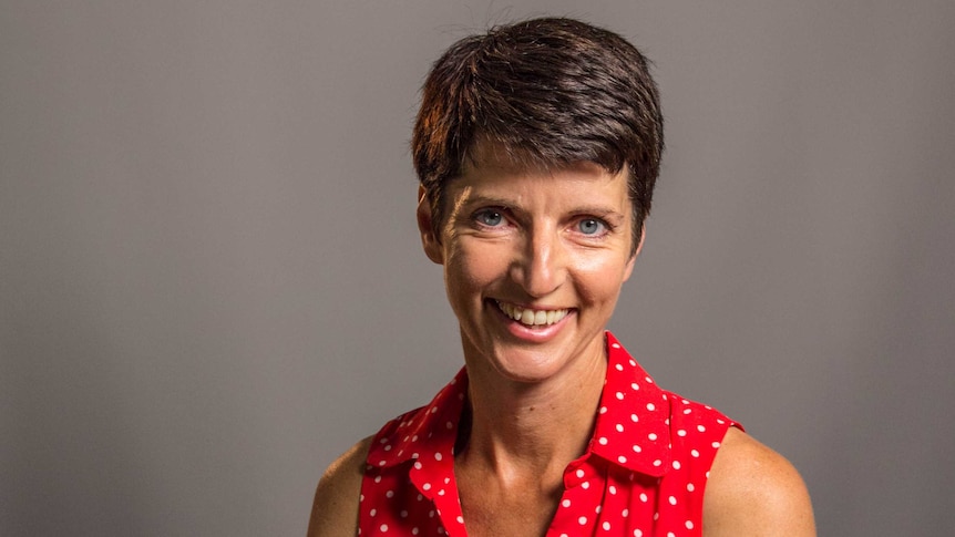 Kate Washington, the Labor member for the New South Wales seat of Port Stephens. She is smiling in a red dress.