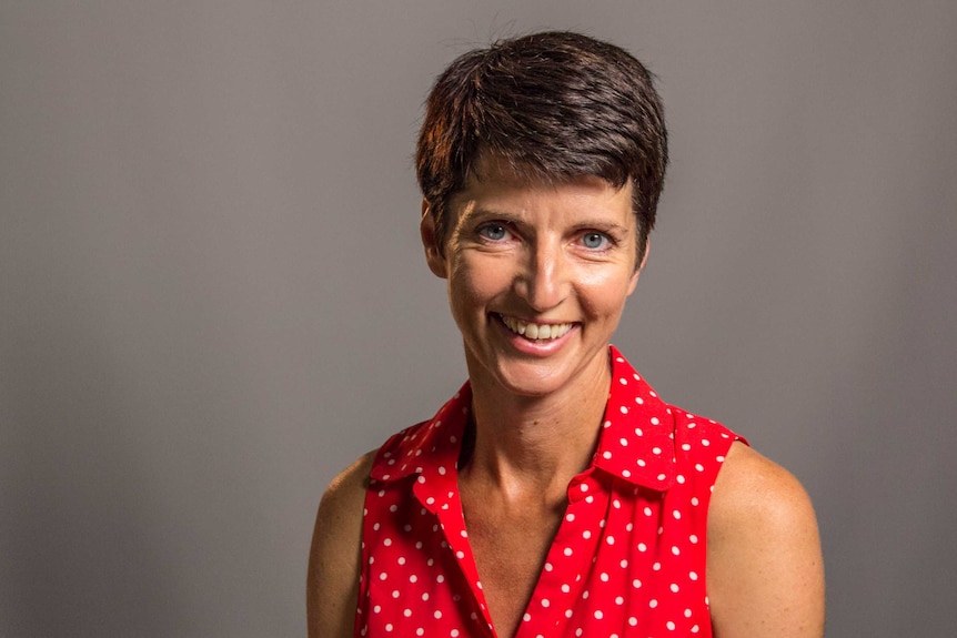 Kate Washington, the Labor member for the New South Wales seat of Port Stephens. She is smiling in a red dress.